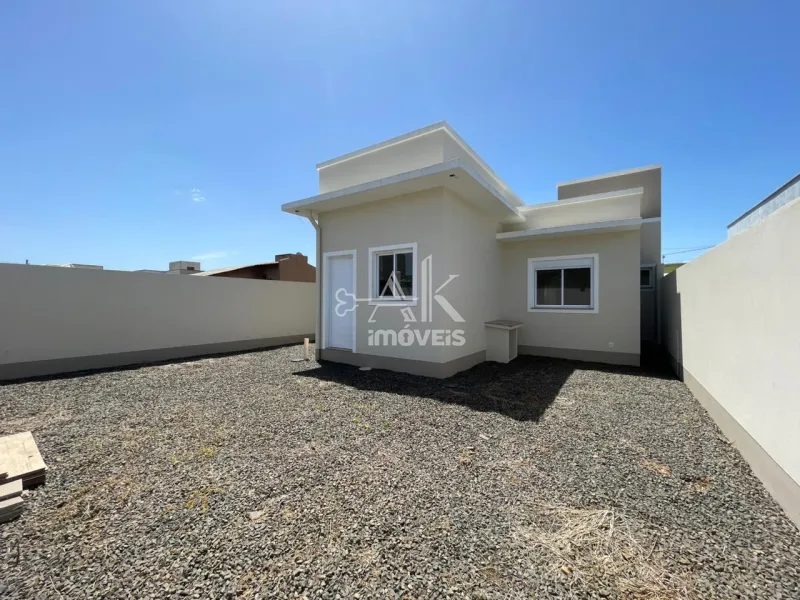 Fundos da casa e pátio amplo cercado por muros.